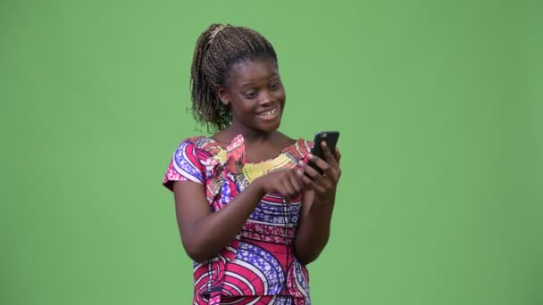 Young African woman using phone and getting good news - Video