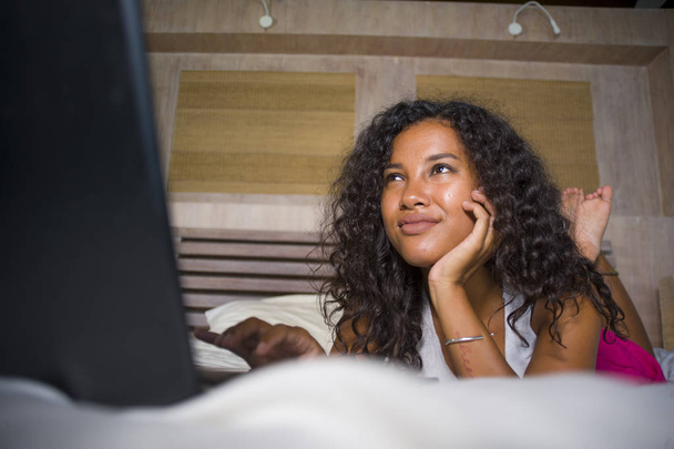 lifestyle portrait of young beautiful and happy black African American woman at home bedroom lying cheerful on bed networking using laptop computer smiling fresh and natural enjoying internet - Foto, Bild