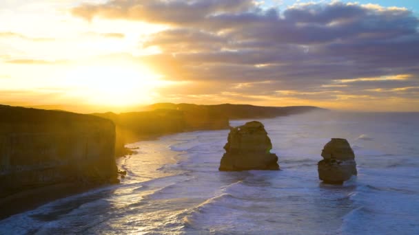 Auringonnousu aamunkoitteessa yli kaksitoista apostolia Marine National Park rantaviivaa kalkkikiveä kallioita ja offshore rock pinot Victoria Australia
 - Materiaali, video