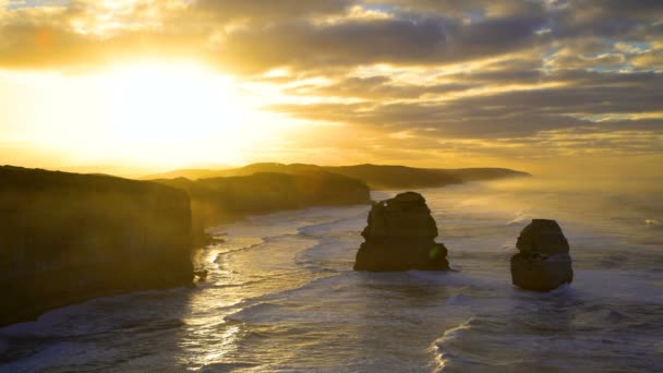 Morning sunlight and cloud formations over limestone cliffs and offshore rock stacks of Twelve Apostles coastline Victoria Australia - Footage, Video