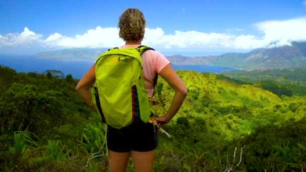 Female hiker looking over remote scenic coastline Nahoe mountains green tropical rainforest remote volcanic Island a paradise in the South Pacific Hiva Oa Marquesas - Footage, Video