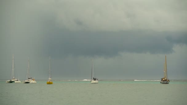 Weergave van storm wolken in de buurt van tropische rif met zeiljachten afgemeerd in lagune Tahiti South Pacific Oceaan archipel  - Video
