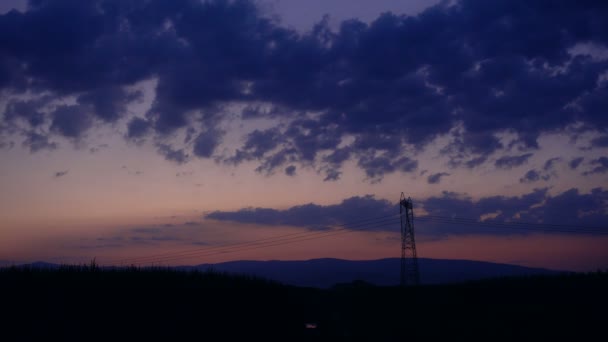 Sylwetka wysokiego napięcia elektrycznego pylonu, Wieża w zachód słońca - Materiał filmowy, wideo