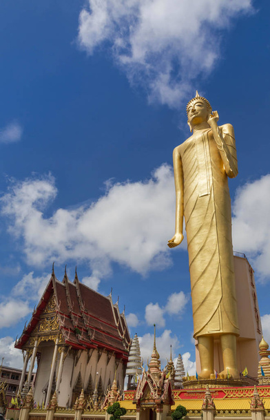 die öffentliche buddha imagae statue, die am wat burapiram tempel roiet, thailand auf blauem himmel steht  - Foto, Bild