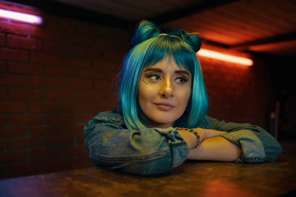 Dívka v nočním klubu poslouchal někomu zatímco sedí u stolu - Fotografie, Obrázek