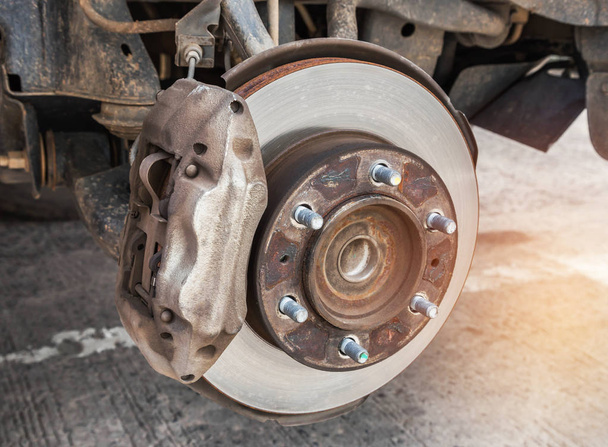 Coche cubo de rueda oxidado con sistema de freno de tambor y suspensión durante el neumático de rueda de cambio
 - Foto, Imagen