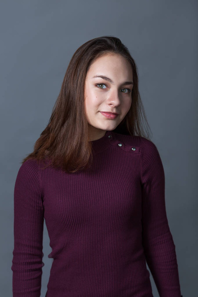 Portrait of happy nice schoolgirl teenager on gray background, studio - Photo, Image