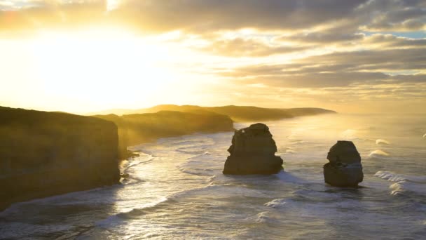 Sabah güneş ışığı bulutlar ve kıyı deniz sis kireçtaşı kayalıklarla Twelve Apostles doğal kıyı şeridi Victoria Australia çevresinde - Video, Çekim