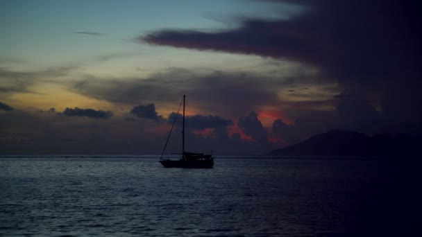 Moorea sunset view at dusk from Tahiti a Polynesian paradise yacht in tropical Island lagoon South Pacific ocean - Footage, Video