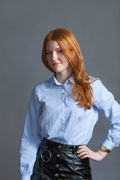 Portrait of happy nice schoolgirl teenager in blue shirt on gray background, studio - Foto, immagini