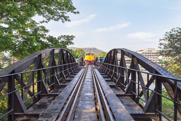 жовтий vintage пасажирський Тайська поїзд переходити через річку Квай міст, Канчанабурі, Таїланд.  - Фото, зображення