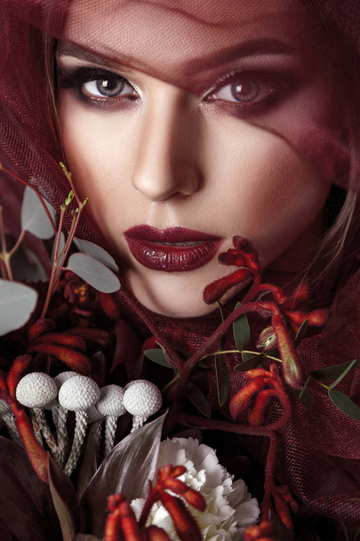 Portrait of young woman with fashionable makeup and eucalyptus bouquet  - Foto, Imagem