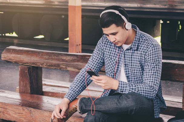 Hipster człowieka słuchać muzyki przy dworcu. - Zdjęcie, obraz