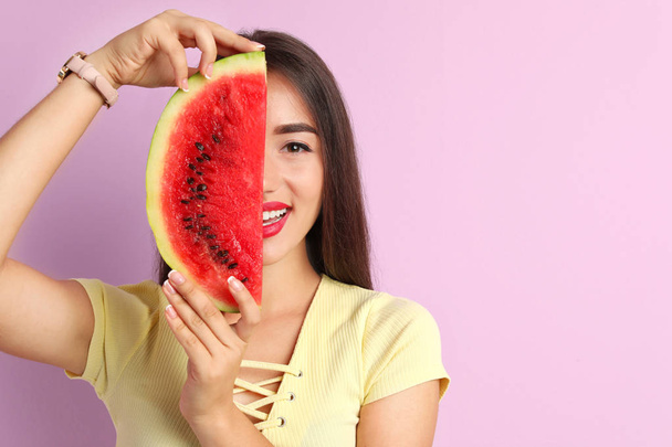 Beautiful young woman posing with watermelon on color background - Fotoğraf, Görsel