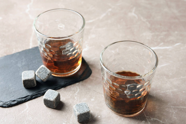Glasses with liquor and whiskey stones on table - Фото, изображение
