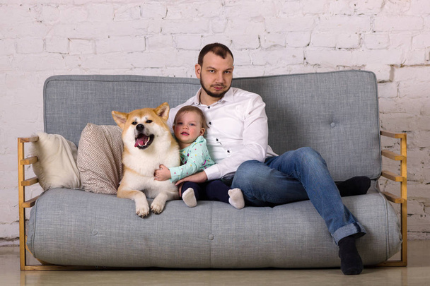 Beautiful young father with little daughter and dog sits on floor - Valokuva, kuva