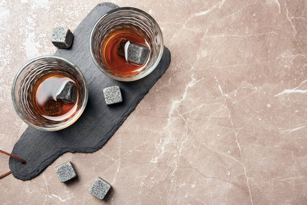 Glasses with liquor and whiskey stones on grey background, top view - Photo, image