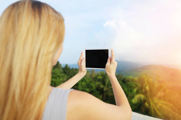 Sunshine photo de femme blonde en utilisant une tablette et en prenant des photos des montagnes de Thaïlande
. - Photo, image