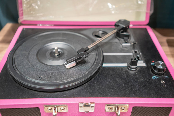 Pink and black modern vinyl player on wooden table. Retro vintage style. - Photo, Image