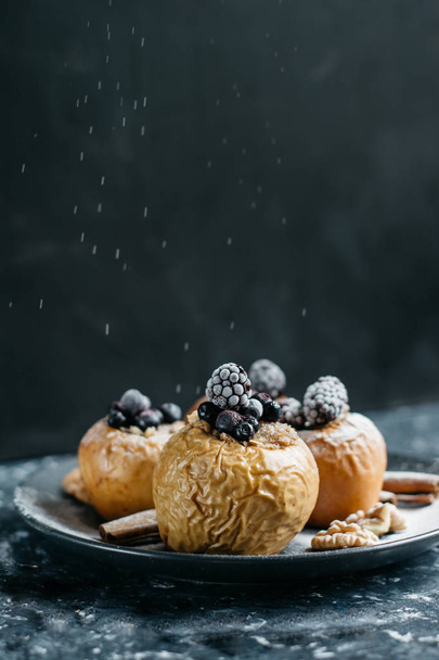 Fruit dessert baked  apples stuffed with blackberry, blueberries, cinnamon, nuts, honey. Autumn or winter dessert. - Foto, Imagen