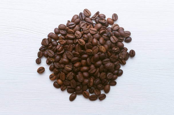 Coffee beans isolated on white wooden table background. - Valokuva, kuva