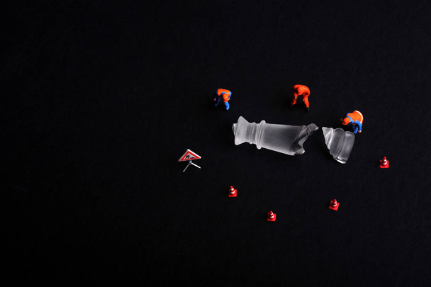 Skupina zaměstnanců figurka miniaturní obklopující část zlomené šachy. Údržba a zpracování koncepčního. - Fotografie, Obrázek