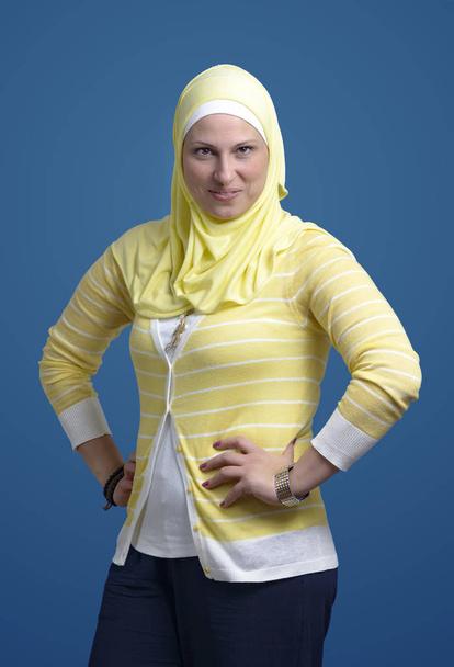 Bela mulher muçulmana confiante sorrindo sobre fundo azul
 - Foto, Imagem