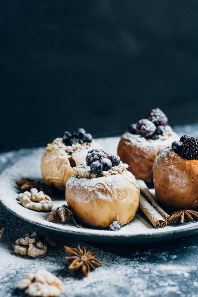 Fruit dessert baked  apples stuffed with blackberry, blueberries, cinnamon, nuts, honey. Autumn or winter dessert. - Φωτογραφία, εικόνα