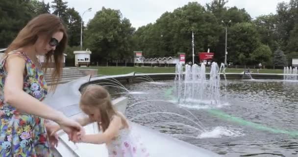 Girl child with mother near the fountain - Video
