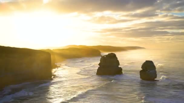 Timelapse amanecer por la mañana sobre los acantilados de piedra caliza con las olas del océano y las pilas de roca mar Doce Apóstoles costa Victoria Australia
 - Metraje, vídeo