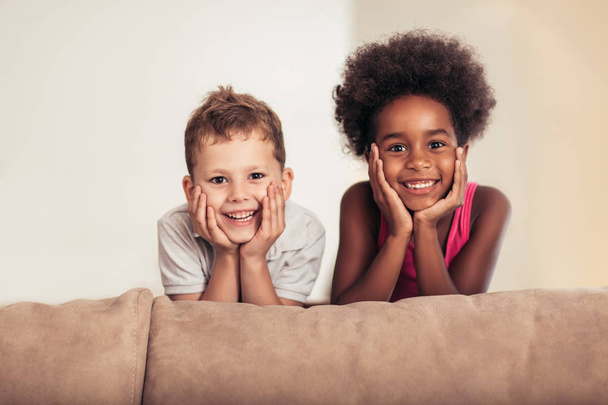 Caucasian boy and African American girl posing at home - Photo, Image