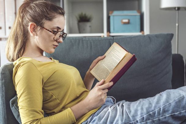 Giovane donna sta leggendo libro  - Foto, immagini