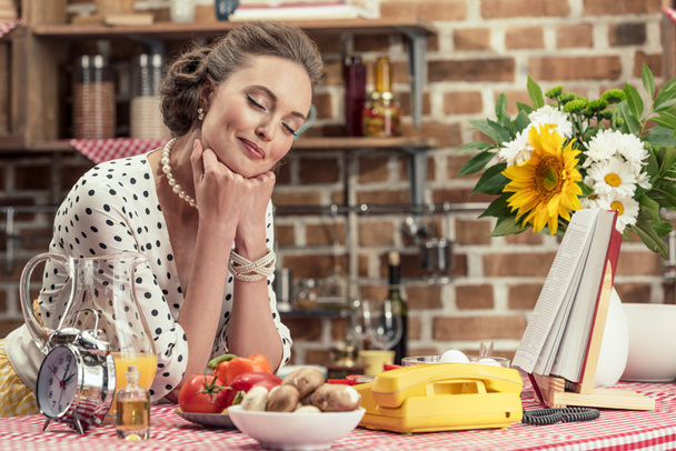 happy adult housewife with closed eyes leaning on table at kitchen - Fotoğraf, Görsel