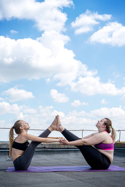 Dos niñas entrenamiento asana barco yoga pose
 - Foto, Imagen