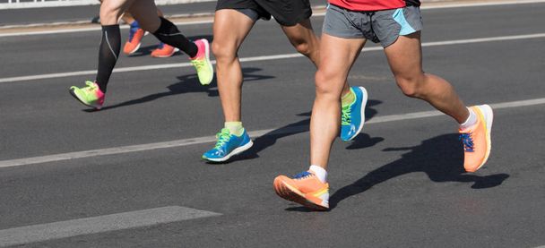Обрезанное изображение марафонцев, бегущих по городской дороге
 - Фото, изображение