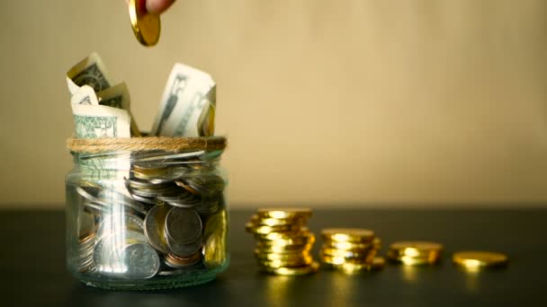 Εξοικονόμηση χρημάτων κέρματος σε βάζο. Σύμβολο της επένδυσης, κρατώντας τα χρήματα ιδέα. Συλλογή μετρητών τραπεζογραμμάτια σε κασσίτερο γυαλί ως moneybox - Πλάνα, βίντεο