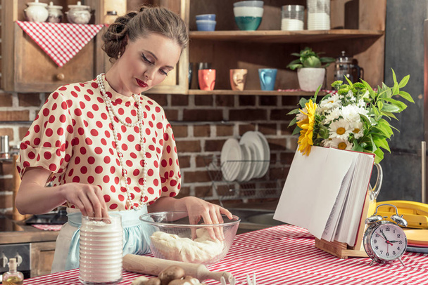 attractive adult housewife kneading dough in bowl at kitchen - Photo, Image