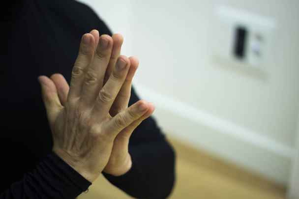 Mannelijke instructeur yoga leraar lesgeven asana pose met mudra hand houding. - Foto, afbeelding