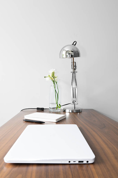 Blocco note bianco, fiore, blocco note bianco e argento, lampada in metallo sulla scrivania in legno - design minimale, composito, moderno
  - Foto, immagini