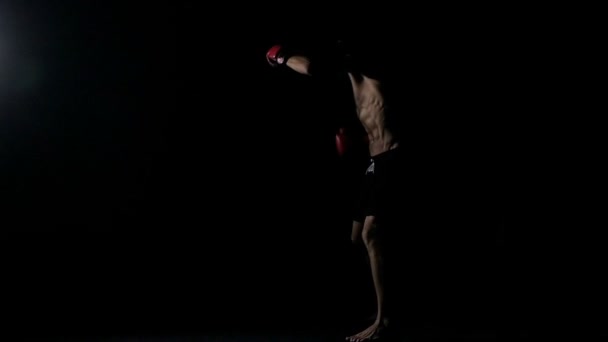 Lihaksikas urheilija harjoittaa karatea tummalla pohjalla
 - Materiaali, video