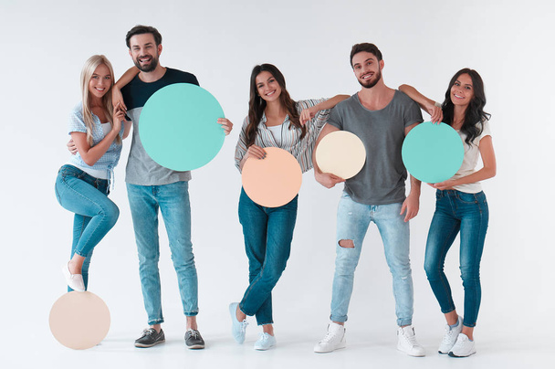 Group of young people isolated on white background. Attractive youth standing together with empty circle advertisement boards. - Φωτογραφία, εικόνα