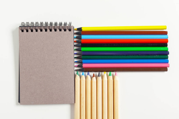 lápis de cor e bloco de notas na mesa
 - Foto, Imagem