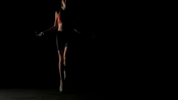 Young intense woman skipping rope. Front shot of athletic woman skipping rope. White young beautiful woman. Shot in slow motion. Film look filter.  - Footage, Video