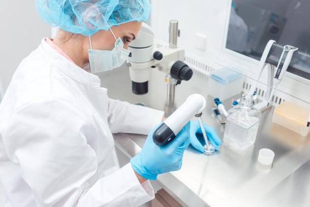 Scientist in lab conducting biotechnological experiment  - Фото, зображення