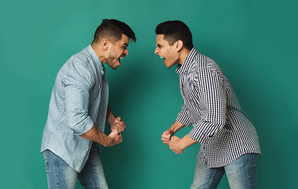 Two arab man shouting at each other at studio background - Photo, Image