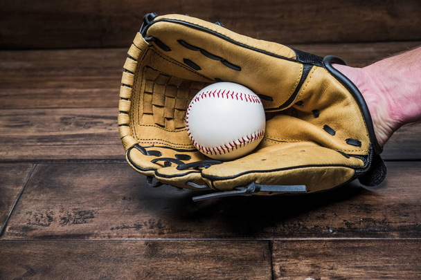 бейсбольна рукавичка на руці з м'ячем
 - Фото, зображення