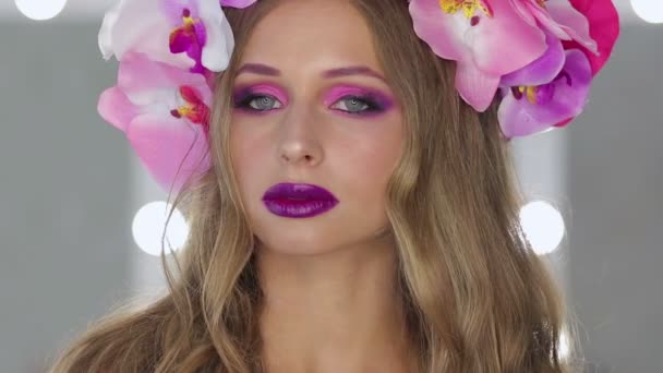 Mujer con flores y maquillaje brillante
 - Metraje, vídeo