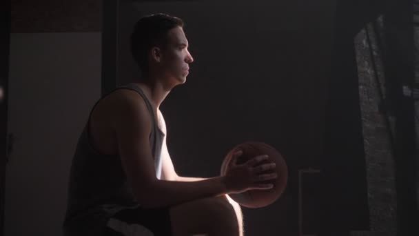 Basketball player sitting and waiting for game to start, going to playground - Footage, Video