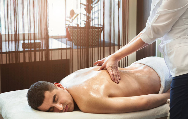 Retrato de un joven recibiendo masaje de espalda
 - Foto, imagen