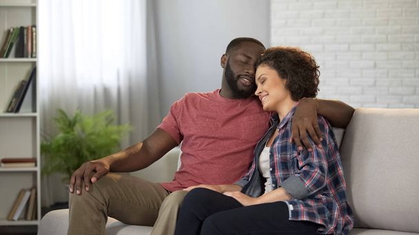 Tender multiracial couple hugging, having rest in home comfort, happy marriage - Φωτογραφία, εικόνα